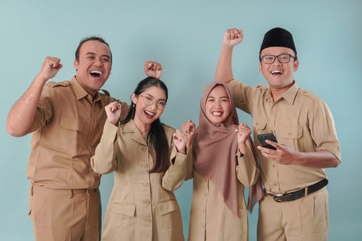Four Indonesian government workers smiling to the camera with a happy successful expression. photo