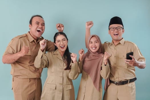Four Indonesian government workers smiling to the camera with a happy successful expression. photo