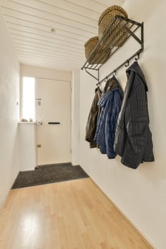 A hallway with coats and a basket on a rack photo