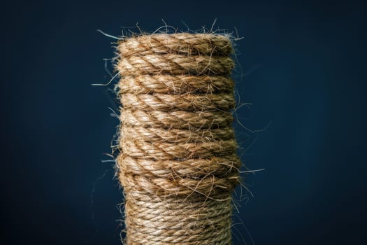 Coiled jute rope standing upright against a dark background photo