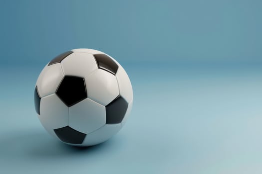 A classic black and white soccer ball resting on a soft blue background photo