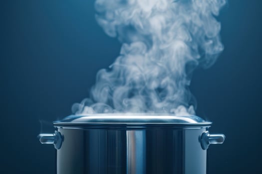 Steam rising from a metal pot on a blue background in a kitchen setting photo