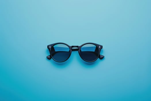 Stylish black sunglasses on a vibrant blue background photo