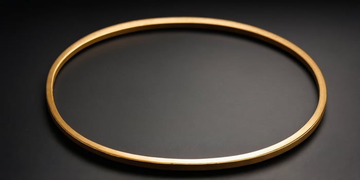 A single golden circular frame sits on a black background. photo