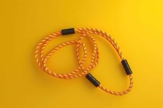 Colorful yellow and orange jump rope on a bright background photo