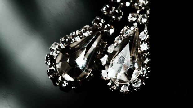 a pair of earrings with diamonds on a black background photo
