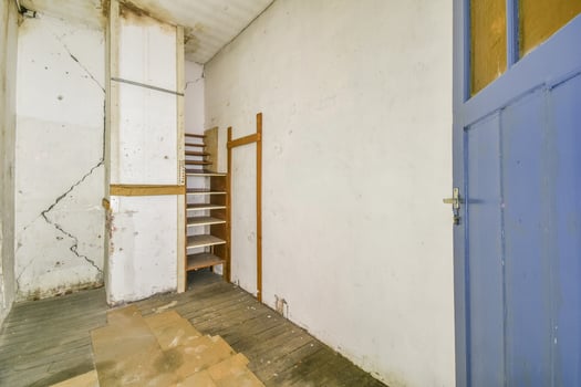 A room with a blue door and wooden stairs photo