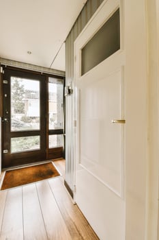 A hallway with a door and a wooden floor photo