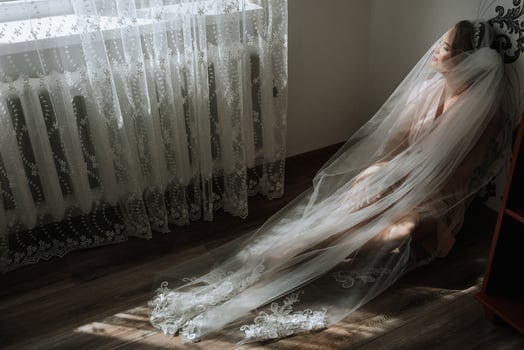 A woman is sitting on the floor with a veil over her head photo