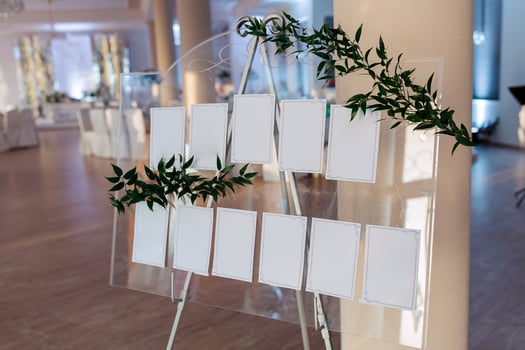 A clear sign with white letters and green leaves on it photo