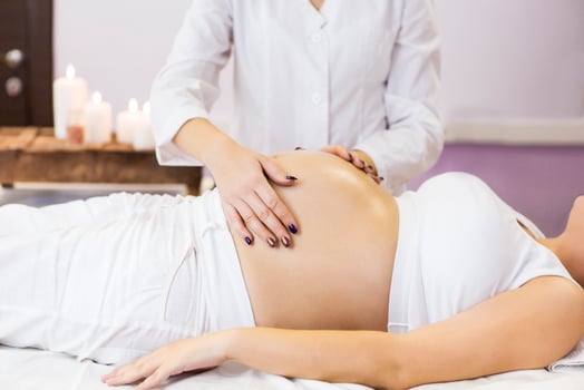 Pregnant woman have massage treatment at spa salon photo