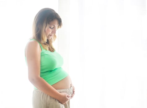 Pregnancy, motherhood- close up of happy pregnant woman photo