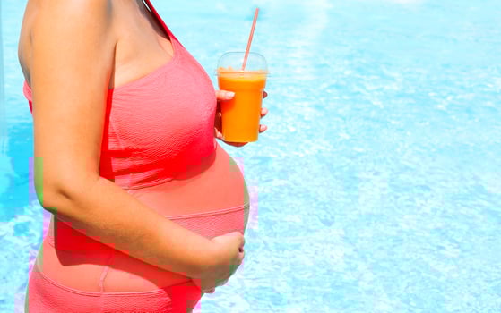Beautiful pregnant woman relaxing outside in swimming pool photo