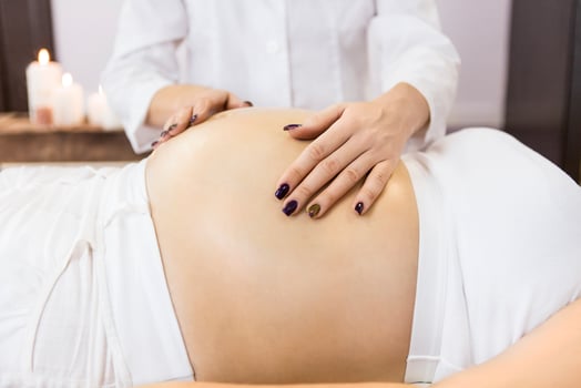 Young pregnant woman have massage treatment at spa photo
