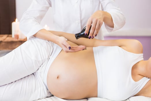 Young pregnant woman have massage treatment at spa photo
