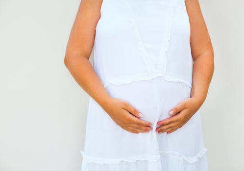 Pregnant woman touching her belly with hands photo