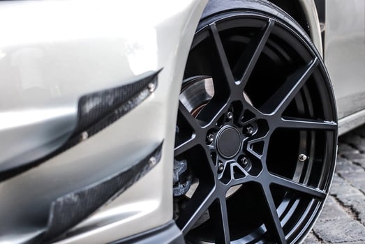 Close up of a wheel of a sports car. Black car rim with low profile rubber. photo