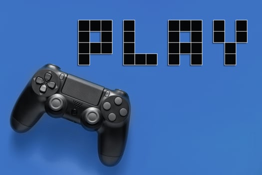 Black modern gamepad and word play on a colored background . Gaming concept photo