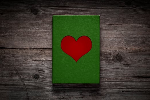 Green paper with a red heart on an old wooden background. Love card concept. Valentine's Day. photo