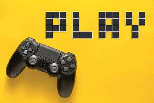 Black modern gamepad and word play on a colored background . Gaming concept photo