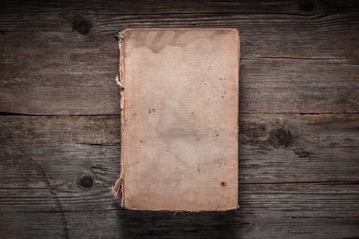 Closed book on vintage wooden background. Old book on the wooden table. Closed book with empty cover laying on wooden table. photo