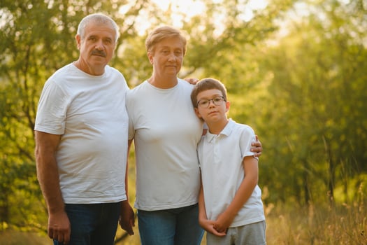 Grandparents walking with they grandson in summer sunset photo