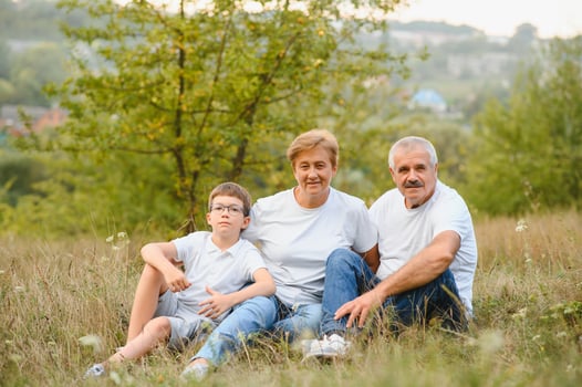 Grandfather grandmother and grandson having fun outdoors in park photo
