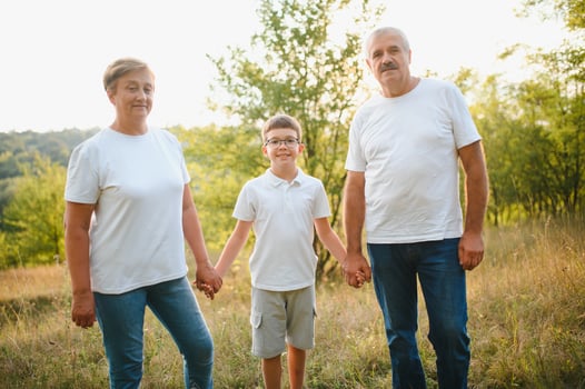 Grandparents walking with they grandson in summer sunset photo