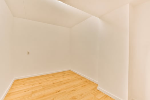 An empty room with a hardwood floor and white walls photo
