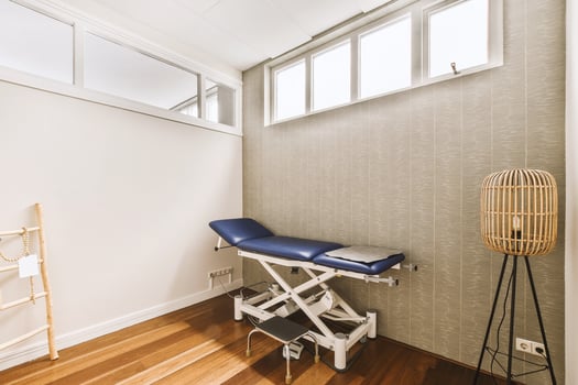 A room with a massage table and a chair photo