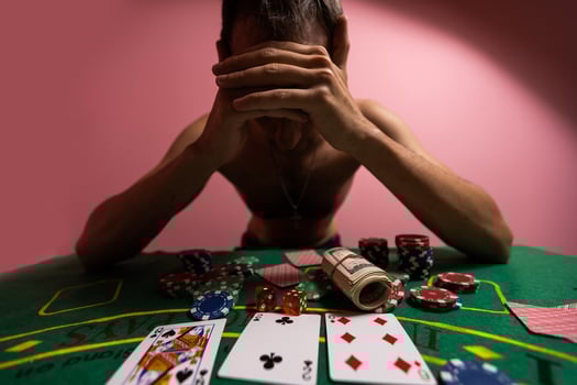 Devastated gambler man losing a lot of money playing poker in casino, gambling addiction. Divorce, loss, ruin, debt, ludopata concept. photo