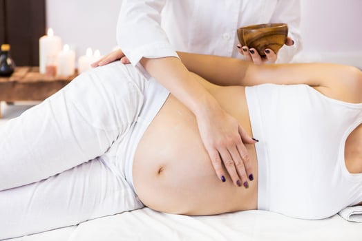 Young pregnant woman have massage treatment at spa photo