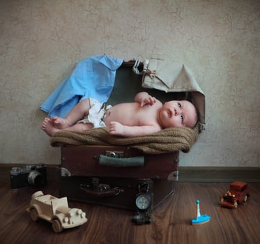 a baby laying in a suitcase photo