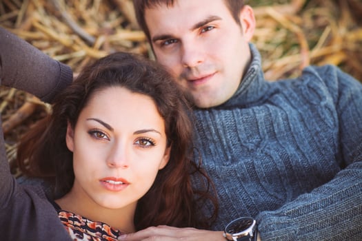 Young couple lying down smiling at autumn background photo