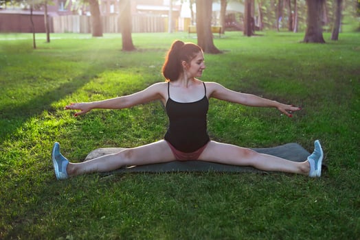 Stretching woman in outdoor exercise smiling happy doing stretches after running photo