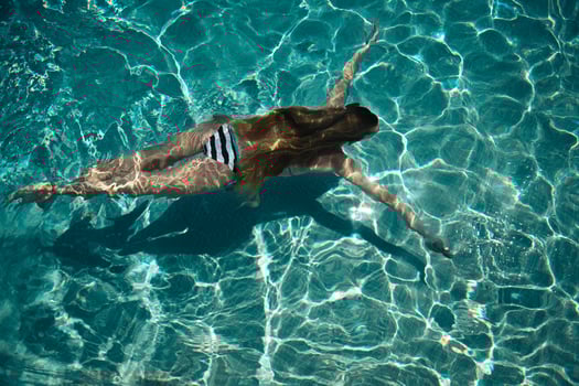 Woman swimming on a blue water pool photo