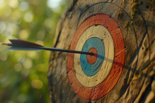 Arrow hitting the center of an archery target on blurred background photo