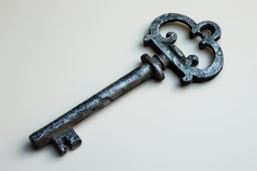 Old worn antique key is lying on a white background photo