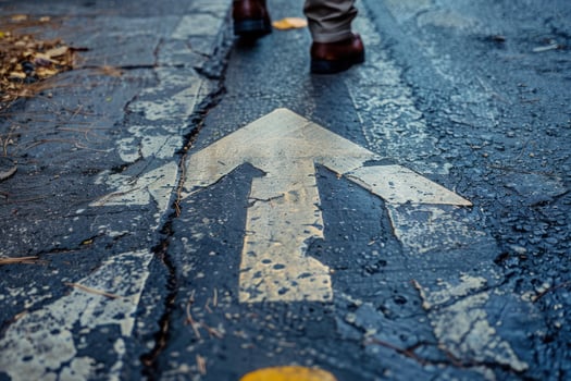 Businessman walking on arrow sign painted on the road photo
