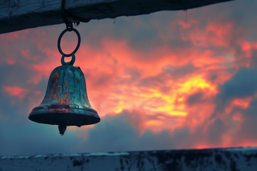 Old rusty bell hanging with dramatic sunset sky background photo