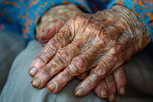 Senior woman showing wrinkled hands resting on lap photo