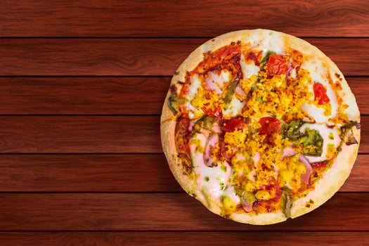 Pizza isolated on wooden table with copy space. photo