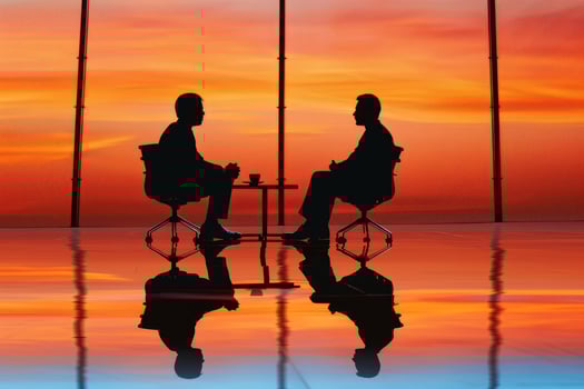 Two businessmen discussing business strategy at sunset in modern office photo