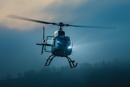 Modern blue helicopter hovering over foggy landscape photo