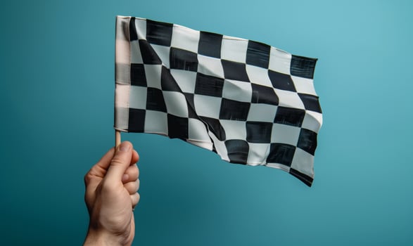 Checkered racing flag in male hand on blue background photo