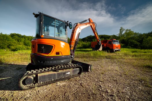 bulldozer stands on a piece of land against the backdrop of a bright blue sky and green trees. construction equipment ready to work photo