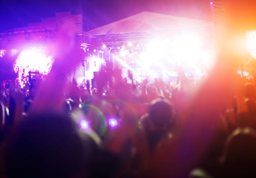 Silhouettes of concert crowd in front of bright stage lights photo