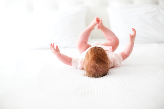 Six month baby playing on bed photo