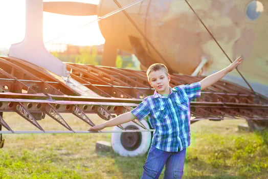 Little boy pilot near the vintage airplane photo