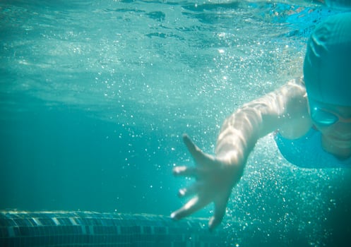 Little girl swims in the pool underwater photo